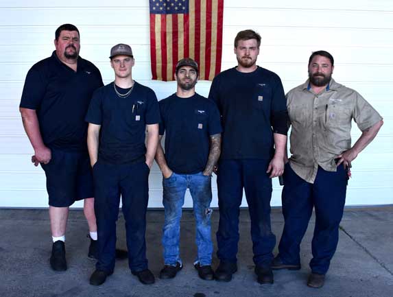 a group of men standing in front of a flag